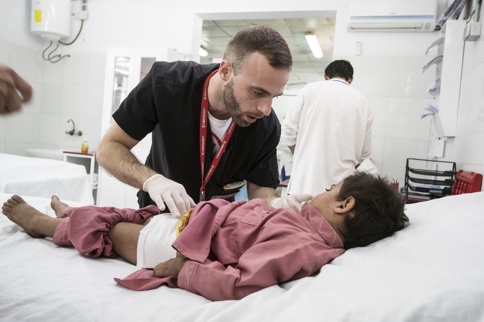 Operatore sanitario assiste una bambina in una struttura di EMERGENCY