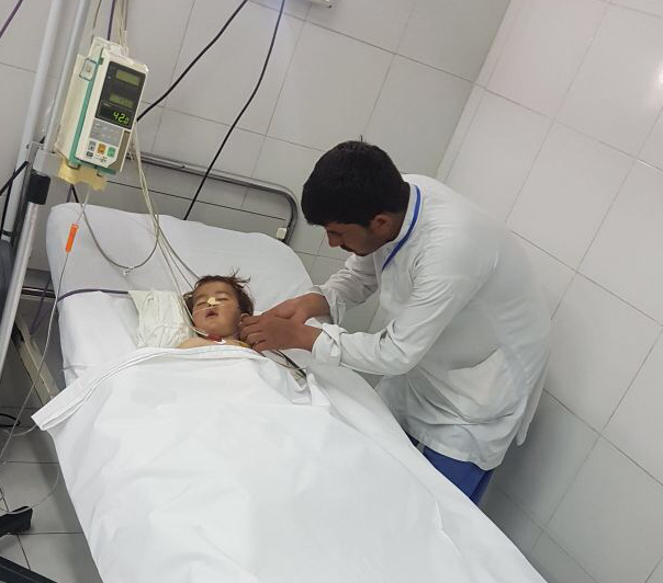 Khalid e un nostro infermiere nel lettino del Centro chirurgico di EMERGENCY a Lashkargah in Afghanistan